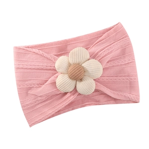 Rosa gestricktes Baby-Stirnband mit 3D-Cordblume auf weißem Hintergrund