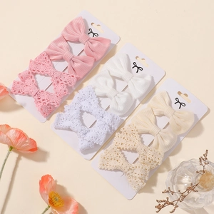 Close-up of 12-piece floral bow hair clips set for toddlers in soft pink and beige colors