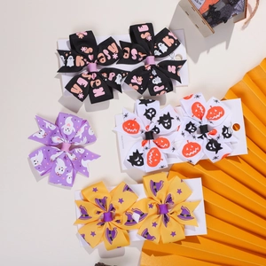 Close-up of five Halloween-themed hair bows with pumpkin, ghost and bat patterns