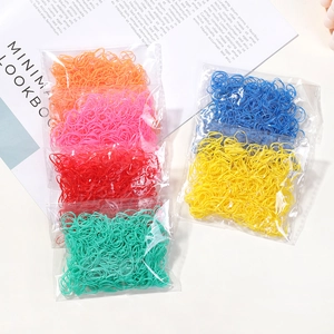 Colorful high elasticity hair bands set in transparent bags on a minimalist magazine background