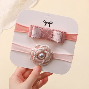 Close-up of pink baby headbands set with floral roses, bows and a faux pearl detail