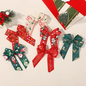 Close-up of five Christmas ribbon bows with reindeer and Santa prints for girls