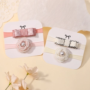 Close-up of baby nylon headbands with camellia flowers and bowknots on display cards