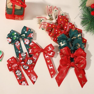 Close-up of red and green Christmas bow hair clips with Merry Christmas embroidery and patterns