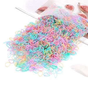 Detailed view of assorted macaron colored elastic hair bands in pink yellow and blue