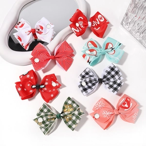 Detail of Christmas bow hair clips set featuring Santa and snowflake festive patterns