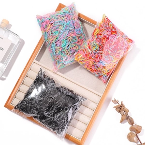 Detail of high-elasticity colorful and black disposable hair ties in a luxury tray