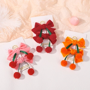 Détail de barrettes à nœuds en velours avec pompons cerises sur cartes blanches pour filles