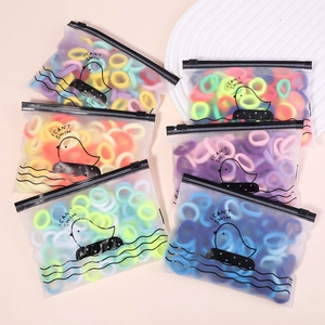 Vue détaillée d'élastiques à cheveux colorés dans un sac givré avec motifs de canard