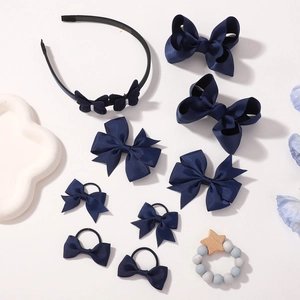Flat lay of navy bow hair clips and headband set for girls on white background
