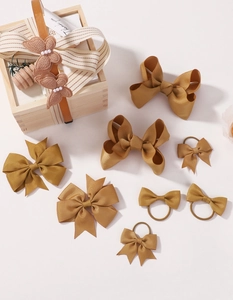 Detailed view of ginger yellow ribbed ribbon bow hair clips and elastic hair ties set