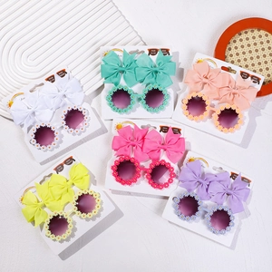 Détail des lunettes de soleil marguerite et pinces à cheveux noeud en six couleurs