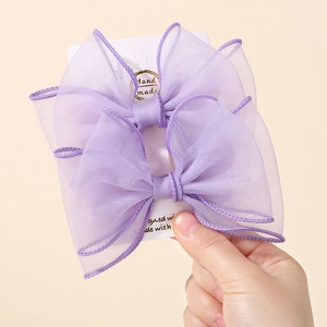 Détail d'un nœud papillon en organza violet multicouche sur une carte faite main