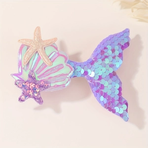 Détail d'une pince à cheveux sirène avec paillettes violettes, coquillages et étoiles