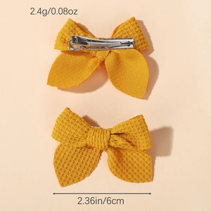 Detailed view of yellow waffle knit bow hair clips with metal crocodile clip backing