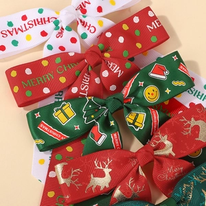 Détail de nœuds en ruban gros-grain de Noël superposés avec motifs rennes et sapins festifs