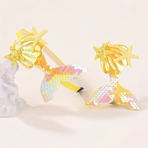 Détail du serre-tête jaune et pince sirène à paillettes avec coquillage et étoile de mer