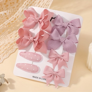 Detail view of 8-piece pink and purple jacquard bow clips set on white display card