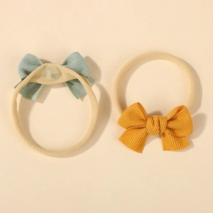 Detail of two-piece waffle texture baby bow headbands in mint green and mustard yellow colors