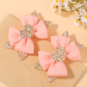 Détail de barrettes à nœuds roses pour filles avec cœurs et étoiles à paillettes brillants