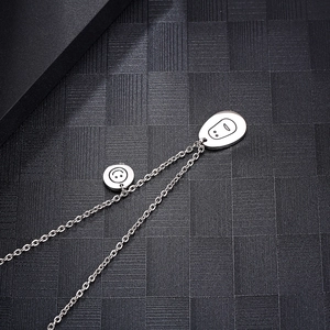 Gros plan détaillé sur des pendentifs emoji sourire et visage minimaliste en argent poli