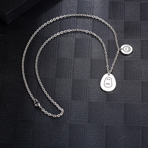 Collier en acier titane avec pendentifs smiley et expression neutre sur chaîne
