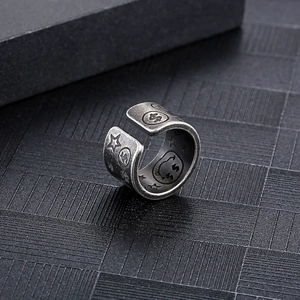 Close-up of vintage steel ring featuring engraved dollar signs and smiley face patterns
