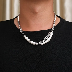 Detailed view of hip-hop layered necklace with pearls and metallic cubes on model