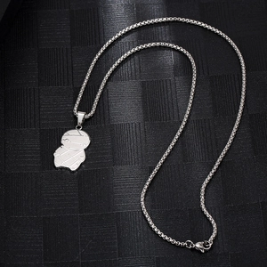 Détail macro du pendentif momie argenté avec chaîne box hip hop sur fond noir texturé