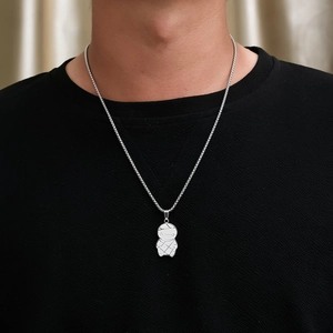 Détail du pendentif momie en argent sur chaîne en acier titane sur un t-shirt noir