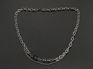 Detailed macro shot of silver double-layered titanium chain with blue sapphire pendant