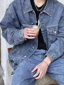 Detailweergave van lichtblauw denim jack met metalen knopen en klassieke borstzakken