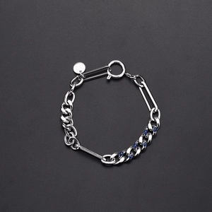 Macro-opname van de zilveren Cubaanse schakelarmband met blauw emaille en ronde hanger
