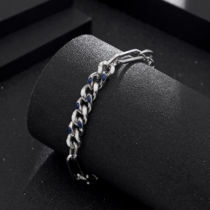 Detail van de zilveren Cubaanse schakelarmband met blauw en wit geëmailleerde schakels