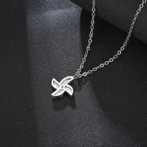 Macro shot of rotatable windmill pendant on S925 silver chain over dark background