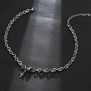 Collier en acier titane avec gemme noire et pendentif étoile croisée sous lumière vive