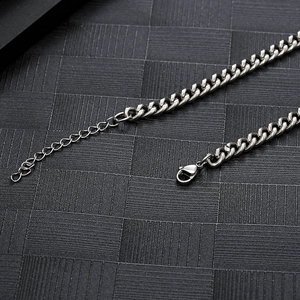 Détail macro du collier chaîne cubaine en acier argenté avec fermoir mousqueton et extension