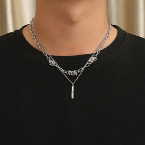 Detail of silver-tone double layered thorn chain necklace with industrial rings and pendant