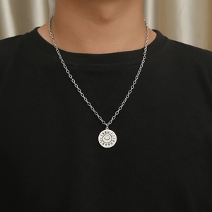 Detail of silver sun coin necklace with smiley face pendant worn on black shirt