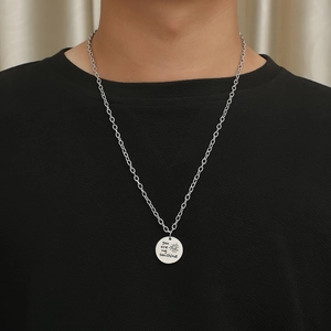 Détail du collier argenté avec pendentif You Are My Sunshine porté sur un t-shirt noir
