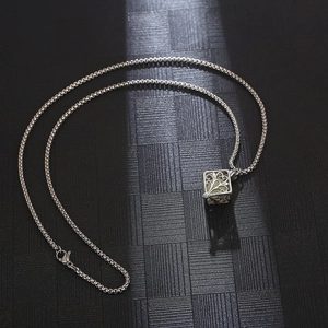 Detailed view of luminous tree of life pendant with glowing hollow steel cube