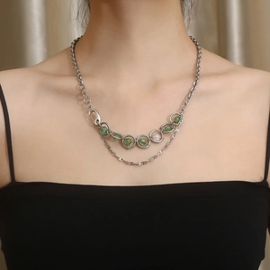 Detail view of double-layer titanium steel necklace with green beads on a model