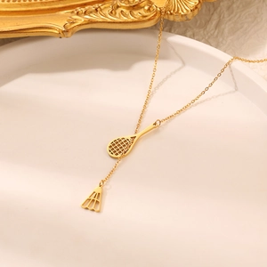 Macro shot of a golden badminton racket and birdie pendant on a titanium steel chain