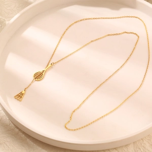 Golden badminton racket and shuttlecock pendant necklace on a round white display tray