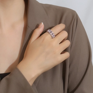 Detailed close-up of pink enamel cuban chain ring on a model with brown suit