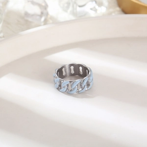 Macro shot of light blue enamel Cuban link ring on white display tray with ice props