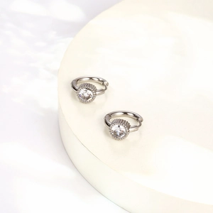Dettaglio dei cerchi in argento con un grande zircone cubico rotondo e texture a grana riso
