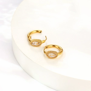 Dettaglio di orecchini a cerchio dorati con zirconi taglio marquise e piccoli grani decorativi
