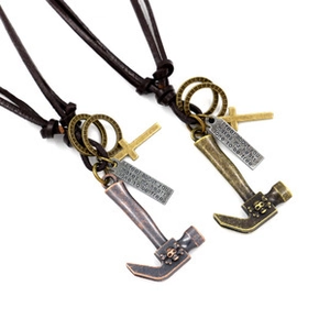 Detail of punk leather cord necklace featuring vintage hammer and cross pendants in two metal tones