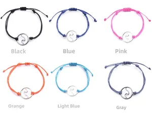 Detail of adjustable handmade wax cord bracelet set with engraved ocean wave charms